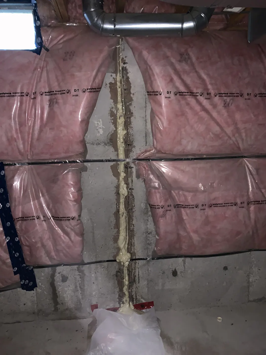 Foundation crack sealed full depth from floor to top behind basement insulation in a Mississauga home