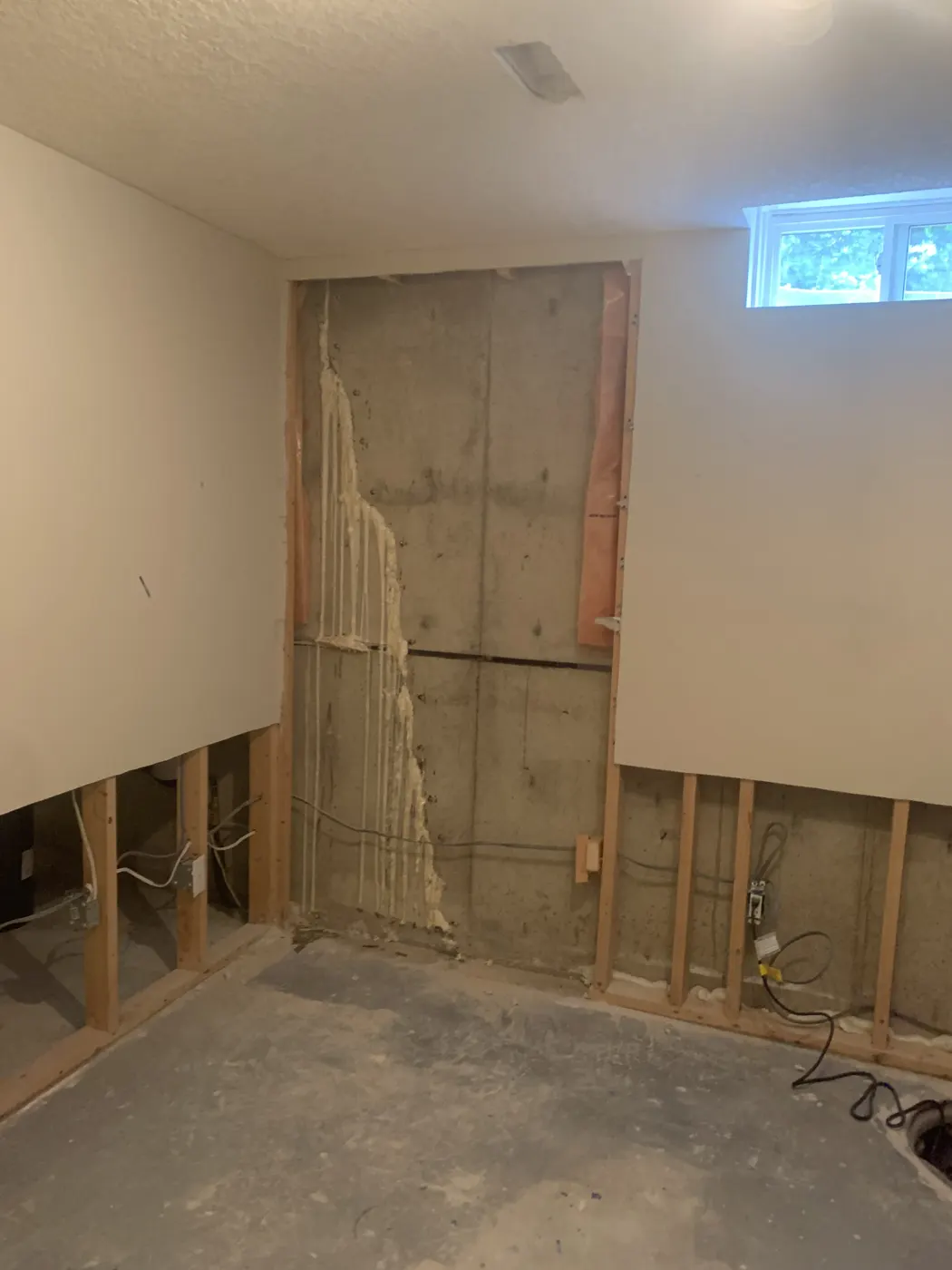 Basement wall with foundation crack sealed by polyurethane injection, drywall ready to close